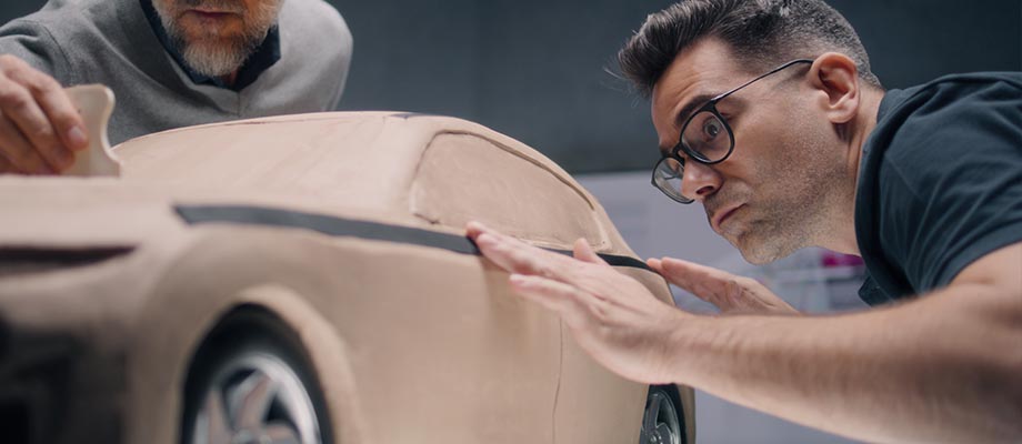 Ein Mann arbeitet an einem Plastilinmodel.